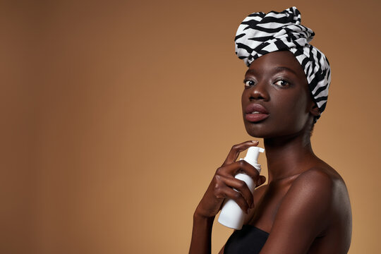 Side of black girl with cream looking at camera