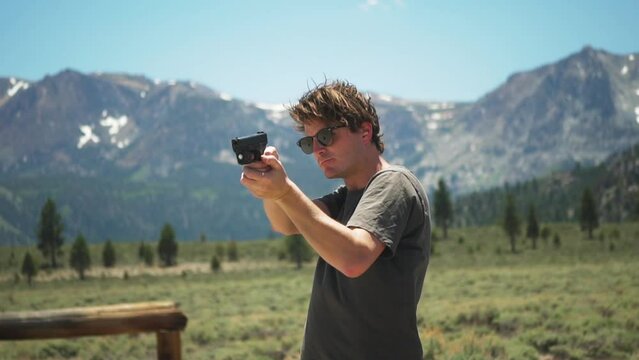 Caucasian shooter firing a handgun at Mammoth Lakes wilderness target range