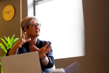 Female professional presenting business report on laptop