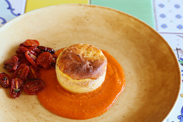 cheese souflle on tomato sauce decorated with cherry tomato confit