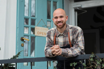 Smiling large charismatic man the owner of the floral shop he posing in front of the camera outside of the shop concept of small business and entrepreneur
