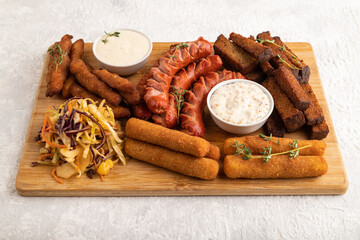 set of snacks: sausages, nuggets, cheese sticks, toast, cabbage salad. Side view.