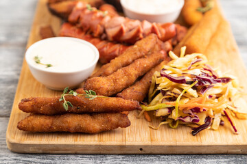 set of snacks: sausages, nuggets, cheese sticks, toast, cabbage salad. Side view, selective focus.