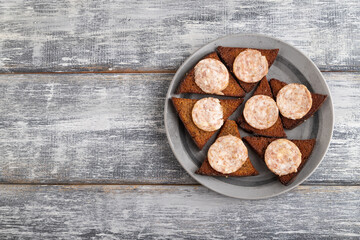 Sausage and toast on a gray plate on a gray wooden background. Top view, copy space.