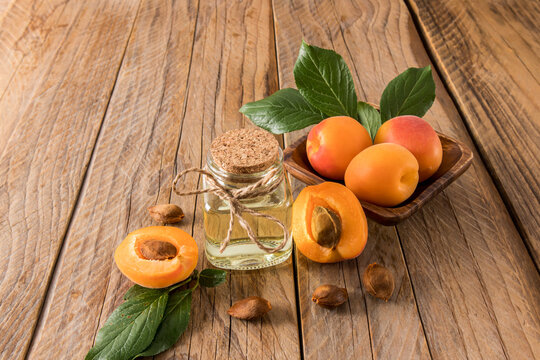 Apricot kernel oil and apricot kernels on wooden background. Stock Photo by  ©Valentyn_Volkov 274249384