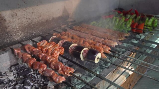 Adana kebab and chicken shish on the grill.
Adana kebab and chicken wings are cooked on the grill.

