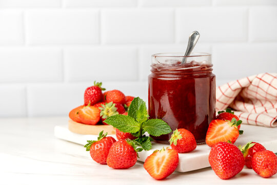 Homemade strawberry jam in glass jar and fresh strawberries 