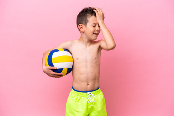 Little caucasian boy playing volleyball isolated on pink background has realized something and...