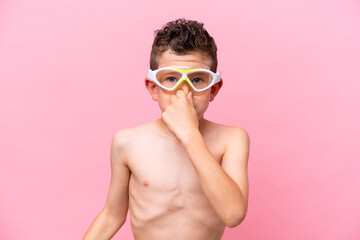 Little caucasian boy wearing a diving goggles isolated on pink background