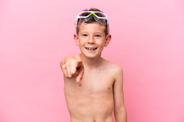 Little caucasian boy wearing a diving goggles isolated on pink background