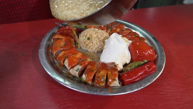 Pouring sauce on Beyti kebab.
Usta Beyti pours butter on his kebab. Grilled meat. Meat between lavash.
