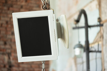 Computer monitor with a blank screen copy space is hanging on the construction hook close up.