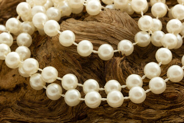 Pearl necklace on wooden background.