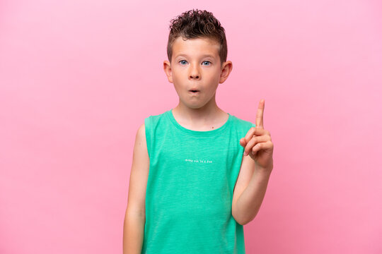 Little caucasian boy isolated on pink background intending to realizes the solution while lifting a finger up