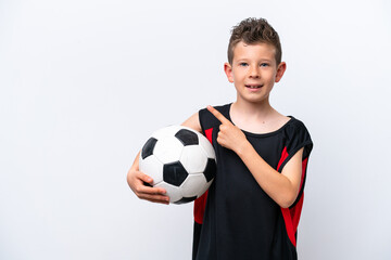 Little caucasian boy isolated on white background with soccer ball and pointing to the lateral