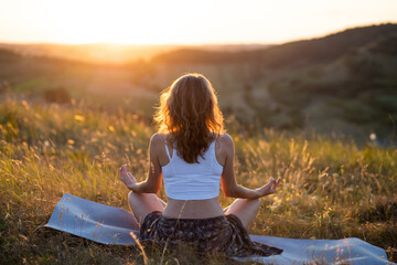 woman meditating outdoors at sunset