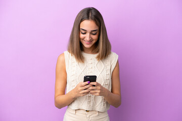 Young caucasian woman isolated on purple background sending a message with the mobile