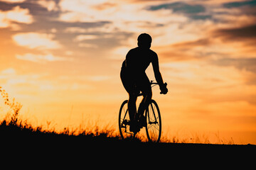 Obraz premium cyclist silhouette at sunset sports and fitness concept