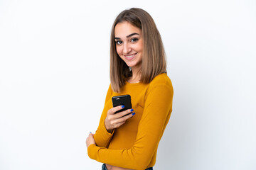 Fototapeta premium Young caucasian woman isolated on white background holding a mobile phone and with arms crossed