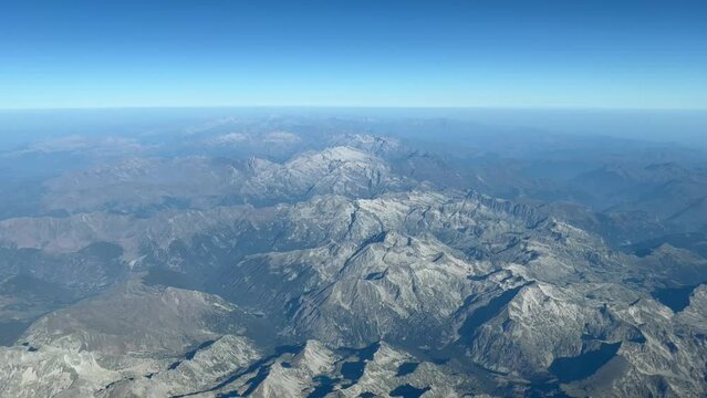Aerial view of the Pyrenees mountains crossing from Spain to France. Pilot point of view at 10000 metres high cruise level, with no snow at all during an extreme hot wave, avidence of climate change.
