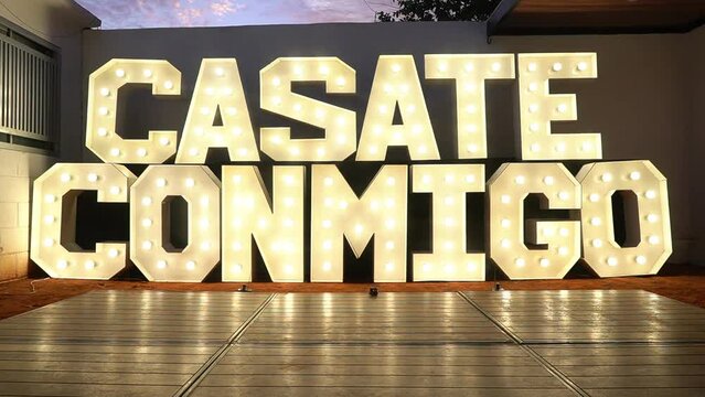 Casate Conmigo, expression of marry me in Spanish to propose marriage to the couple, give engagement ring, couple commitment, proposal in giant wood led lettering design