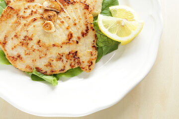 Asian food, butter pan fried swordfish fillet served lemon on lettuce