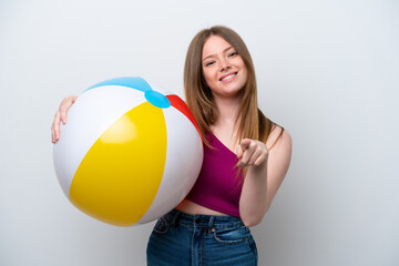 Young caucasian woman holding beach ball isolated on white background pointing front with happy expression