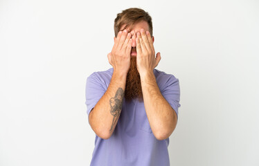 Young reddish caucasian man isolated on white background covering eyes by hands