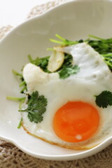 Sunny side up fried egg and coriander leaf for healthy breakfast 