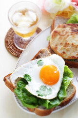 Sunny side up fried egg and coriander leaf open sandwich for gourmet breakfast