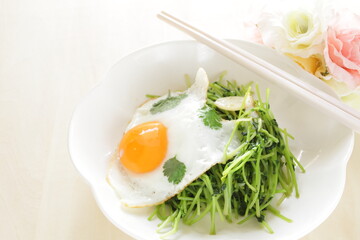 Chinese food, Pea sprouts stir fried vegetable with sunny side up fried egg on top