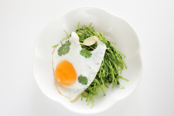Chinese food, Pea sprouts stir fried vegetable with sunny side up fried egg on top