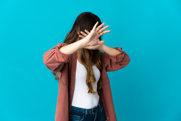 Young caucasian woman isolated on blue background nervous stretching hands to the front