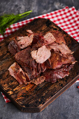 Pieces of baked meat on cutting board on gray background