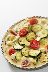 Prepared zucchini and cherry tomato in egg wash for quiche cooking ingredient 