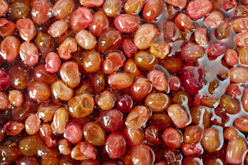 Close-up shot of red ripe gooseberry jam in sweet syrup.