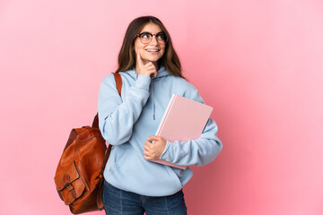 Young student woman isolated on pink background thinking an idea while looking up