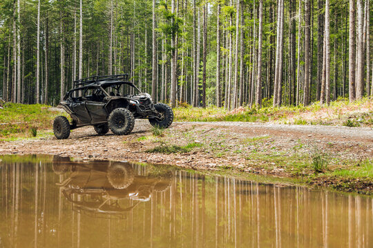 UTV in the woods dirty from mud in front of water