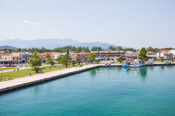 Obraz premium Panoramic view of Keramoti, small town, and port in Greece. Seascape. Beautiful blue water and sky. Summer day. Travel holiday vacation. 