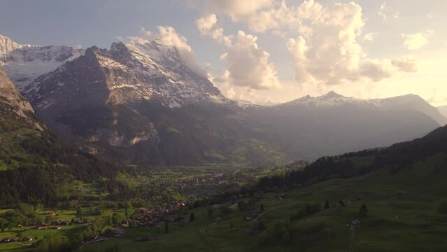 Aerial drone footage pushing out revealing moody views of picturesque mountain village in front of eiger north face