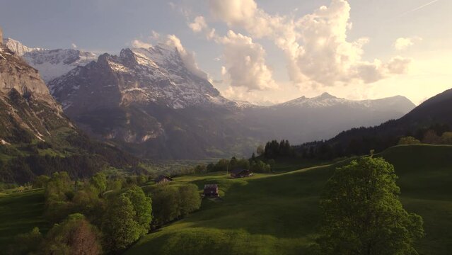 Aerial drone footage left to right revealing views of picturesque mountain village in front of eiger north face in swiss alps