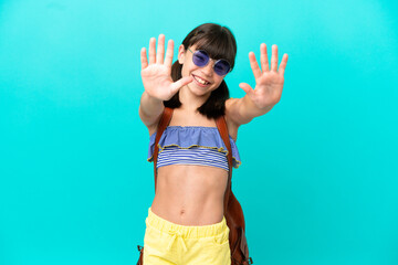 Little caucasian kid going to the beach isolated on blue background counting ten with fingers
