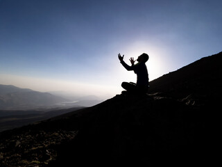 man begging and praying to god on top of mountains