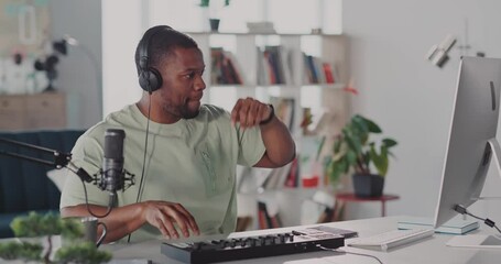 At home black handsome young man broadcasting online video lesson music tutorial playing electronic songs wearing headphones speaking on webcam.