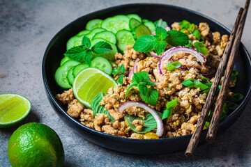 Thai chicken salad larb gai with onion, cucumber and mint. Asian food concept.