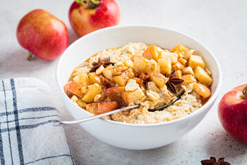 Autumn oatmeal with caramelized apple and cinnamon. Winter cozy recipe. Healthy comfort food.