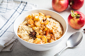 Autumn oatmeal with caramelized apple and cinnamon. Winter cozy recipe. Healthy comfort food.