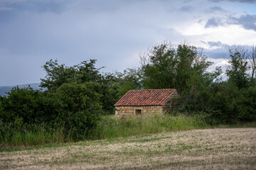 Stone hut in a field on a cloudy spring day, Auvergne, France