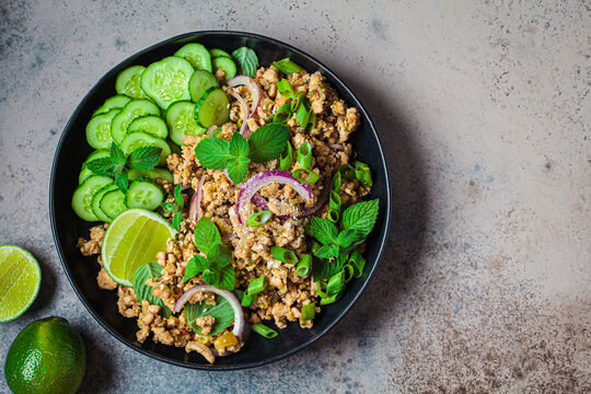 Thai chicken salad larb gai with onion, cucumber and mint. Asian food concept.