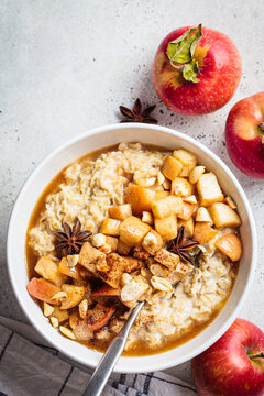 Autumn oatmeal with caramelized apple and cinnamon. Winter cozy recipe. Healthy comfort food.